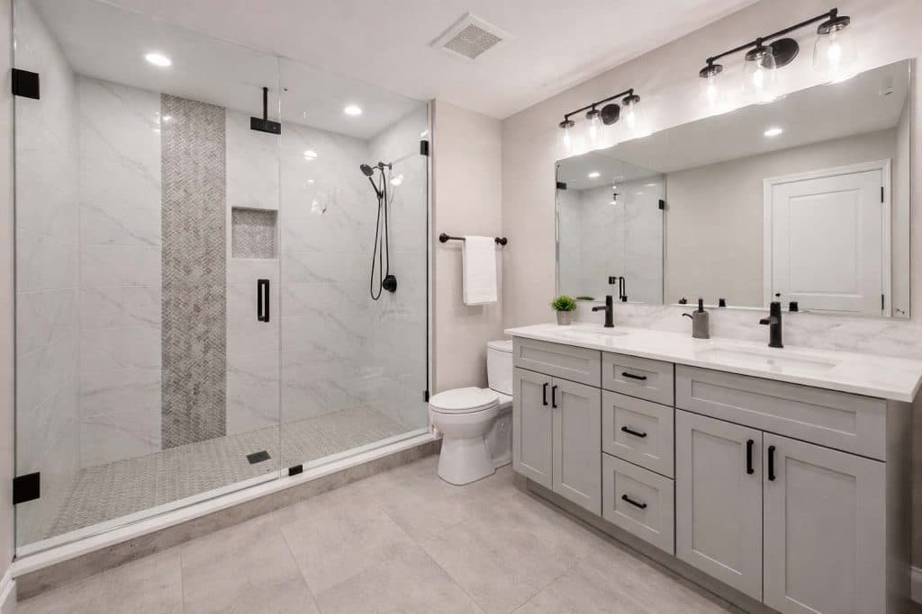 Bathroom with long white double vanity and tiled walk-in shower