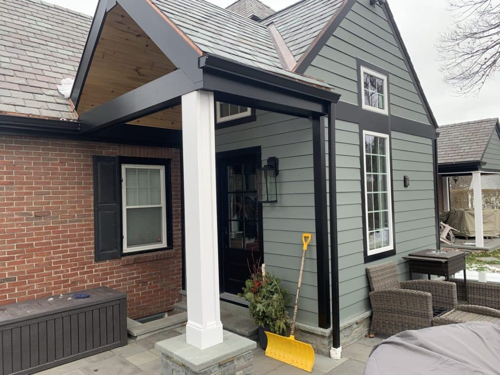 New covered entry portico built by HouseCraft on a brick and clapboard home