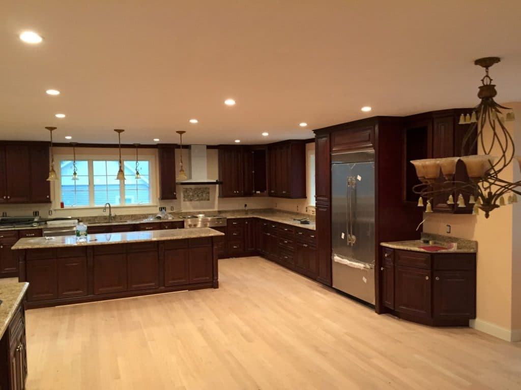 Kitchen with cherry cabinets, stone counters and stainless refrigerator