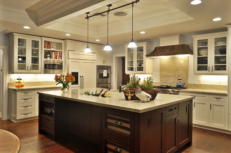 Kitchen with dark wood island, glass-front upper cabinets and pendant lights