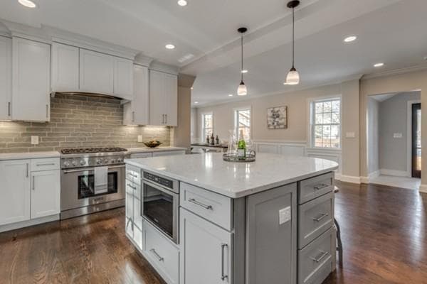 Kitchen with island, tile backsplash and pendant lights